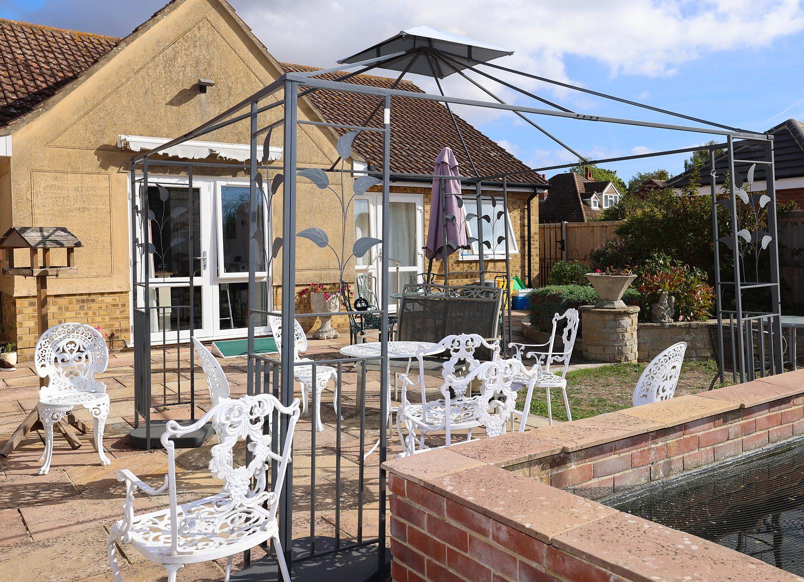 The rear of Stronvar Rest Home and its garden patio on a bright day