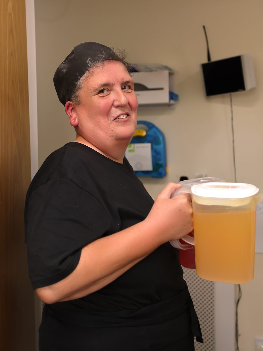 A member of the Stronvar team smiling on the drinks round, jug in hand